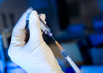 Scienziato alle prese con la siringa e il vaccino